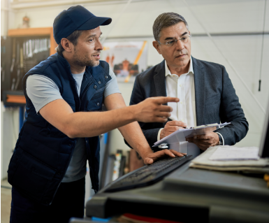 een man in pak en een man in werkkleding zijn aan het overleggen